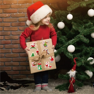 Detailed holographic Christmas stickers on a gift box held by a girl in a festive setting