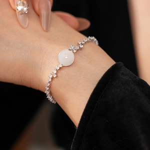 Macro shot of a silver zircon bracelet featuring a round white chalcedony charm