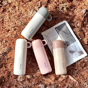 Detail view of four Morandi colored stainless steel vacuum flasks with loop carry handles