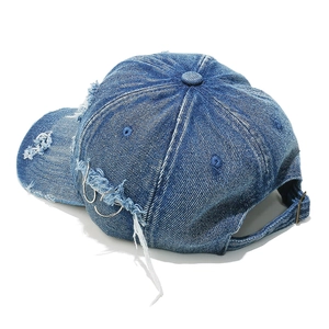 Detail of distressed denim baseball cap featuring metal rings and adjustable back buckle