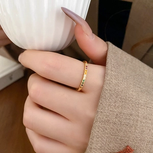 Close-up of golden ring set with colorful rainbow cubic zirconia and polished finish