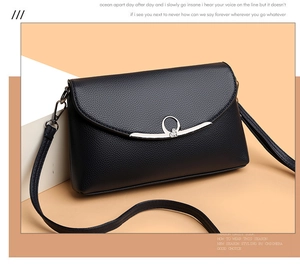 Detail of black lychee texture leather shoulder bag with a silver metal decorative buckle