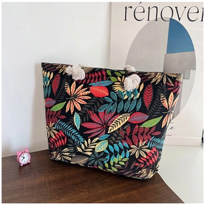 Detail of canvas tote bag with colorful leaf prints and thick cotton rope handles