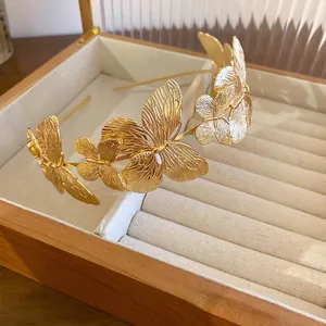 Elegant gold butterfly headband with matte finish on jewelry box display