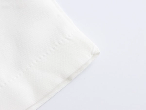 Close-up of white elegant fabric with precise stitching and refined texture detail