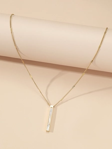 Dettaglio di una collana in acciaio al titanio dorato con ciondolo in madreperla bianca