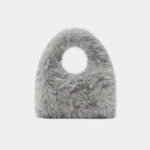 Gros plan sur petit sac à main gris en fausse fourrure avec poignée ovale et texture douce