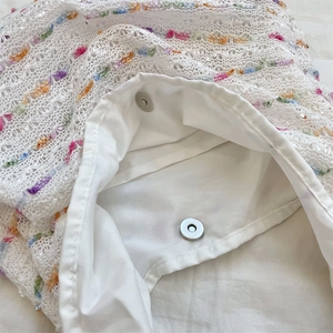 Close-up of white crochet tote bag showing interior lining and silver magnetic snap button