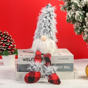 Detail of plush Christmas gnome with gray hat and red plaid legs sitting on books