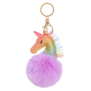 Close-up of rainbow unicorn plush charm with purple fur ball and golden metal clip