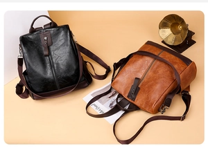 Close-up of litchi texture PU leather backpacks with vertical zippers in black and brown