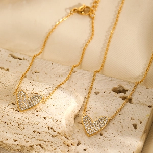 Detailed close-up of gold-plated heart jewelry set with micro-pave white zircon stones
