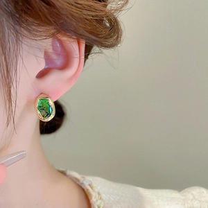 Close-up of French vintage gold irregular geometric stud earring on model ear