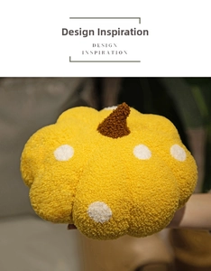 Close-up of a yellow polka dot pumpkin plush pillow made of soft textured fabric