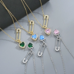 Macro shot of safety pin necklaces with heart-shaped gems and pavé zircon settings