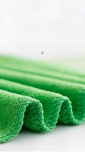 Vue macro d'un chiffon en microfibre verte avec couture surjetée serrée et texture douce de haute qualité
