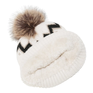 Detail einer Winter-Strickmütze mit dickem Fleecefutter und Kunstpelz-Bommel in Creme