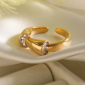 Macro detail of gold open ring featuring sparkling zircon stones on ivory silk