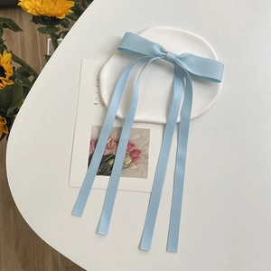 Light blue double-layer ribbon bow hair clip displayed on a white decorative cloud tray