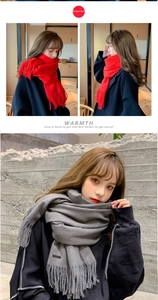 Detail of red and grey cashmere feel scarves with soft fringe edges and label textures
