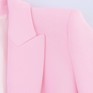 Detail of pink blazer neckline and shoulder showing fine fabric texture and neat stitching