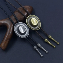 Close-up of vintage bronze and silver bolo ties with cowboy hat charms on braided cords