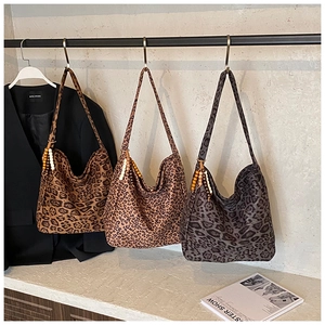 Detailed view of leopard print shoulder bags with wooden bead charms on the straps