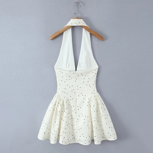 Robe dos nu à pois avec taille ajustée et jupe évasée sur un cintre en bois