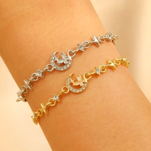Close-up of gold and silver plated bracelets featuring moon, star and butterfly charms