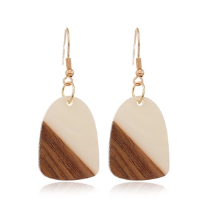 Detail of vintage geometric earrings with beige resin and brown wood texture stitching
