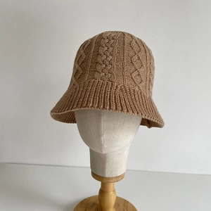 Detailed view of khaki knit bucket hat with thick cable stitch and ruffled edge