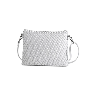 Minimalist white woven leather crossbody bag with adjustable strap on white background