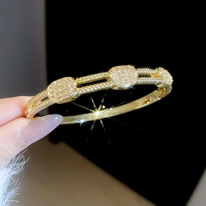 Macro shot of 18k gold plated bracelet with square pavé zircon blocks on black background