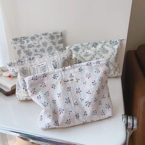 Detailed set of four printed cotton makeup bags with floral patterns and zipper closure
