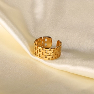 Macro shot of 18K gold plated wide watchband mesh ring on beige silk background