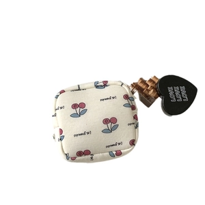 Beige cherry print canvas makeup bag with a black heart LOVE pendant and zipper closure