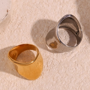 Close-up of irregular 18K gold and silver plated geometric rings on sand background
