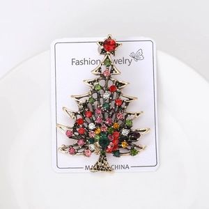 Macro detail of Christmas tree brooch with colorful rhinestones on display card