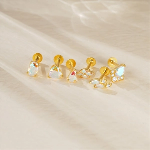 Macro view of 925 silver gold-plated opal stud earrings set on soft fabric
