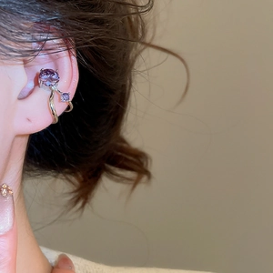 Detail view of a double layer ear cuff with purple zircon stones on a female model's ear