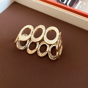 Detailed macro view of gold textured metal bangle with unique hammered finish and oval links