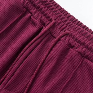 Primer plano de la textura de gofre granate y la cintura elástica con cordón del pantalón