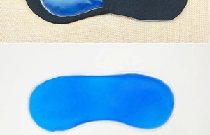 Detail of blue gel insert being placed into a black fabric eye mask for therapy