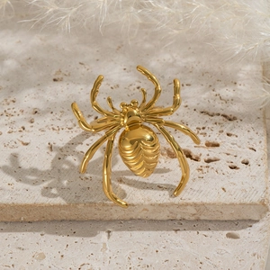 Macro view of gold spider ring with polished finish on a natural stone base