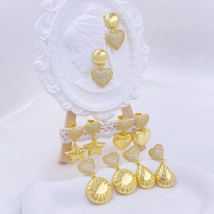 Detailed close-up of gold star and heart earrings with zircon inlay on decorative stand