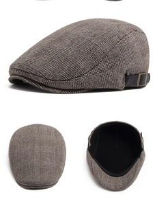 Detail of wool newsboy cap showing vintage plaid pattern and adjustable side buckle
