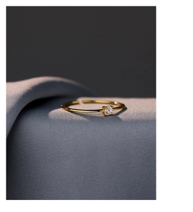 Macro shot of minimalist gold S925 silver ring featuring a sparkling white zircon stone