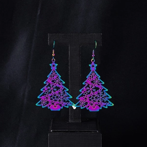 Dettaglio macro di orecchini colorati ad albero di Natale su supporto nero elegante