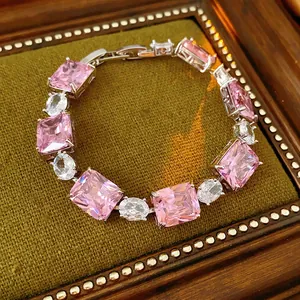 Elegant silver chain bracelet with square pink zircon and oval clear stones on green velvet