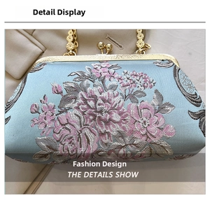 Close-up of pink flower embroidery on light blue satin with gold vintage clasp